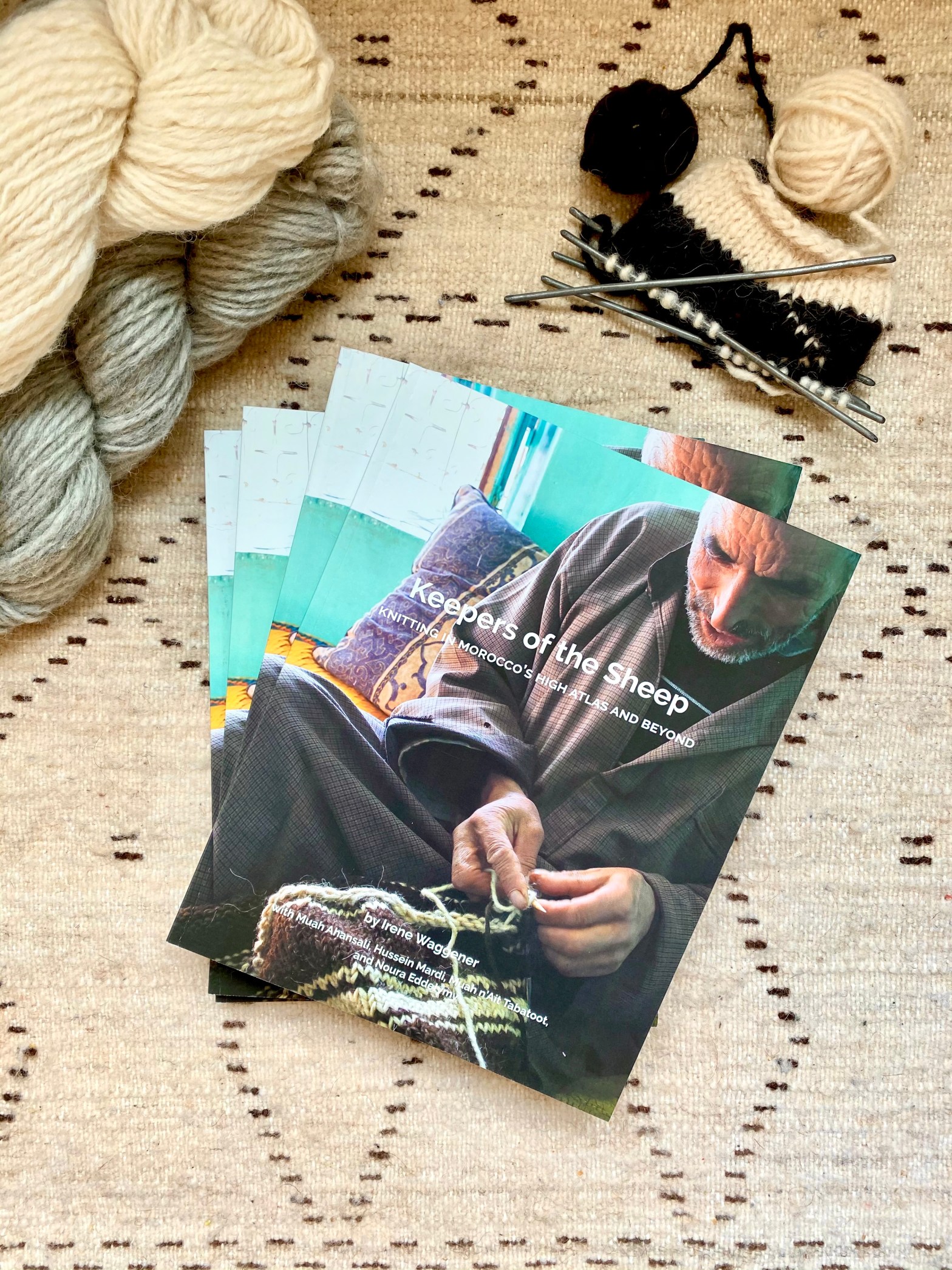 book keepers of the sheep knitting in morocco's high atlas and beyond displayed on rug with yarn and knitting